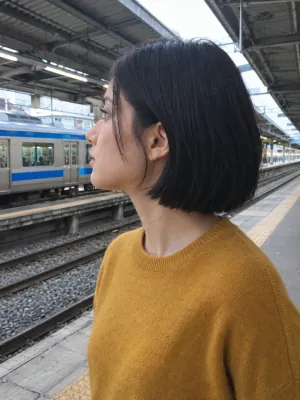 A woman seen from the side on a train platform